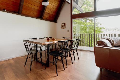 a dining room with a table and chairs and a balcony at Spacious North Cascades Riverside A-Frame with Mt Baker Views - Dog-Friendly in Concrete