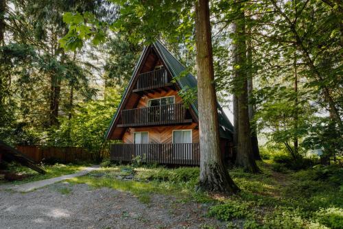 a cabin in the woods with a tree at Spacious North Cascades Riverside A-Frame with Mt Baker Views - Dog-Friendly in Concrete