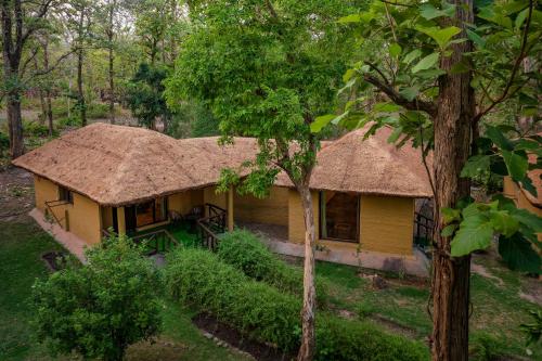 a house with a straw roof in a forest at Bijrani Jungle Camp by Fairlink in Rāmnagar