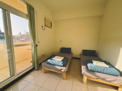 a room with two beds and a large window at 東海獨角獸 in Longjing