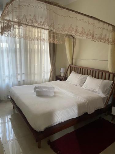 a bedroom with a large bed with a canopy at Cozy Home in Entebbe in Entebbe