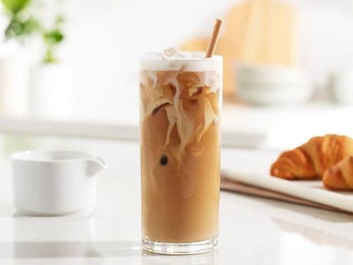 a glass of iced coffee sitting on a table at 9 Residences Seminyak in Seminyak