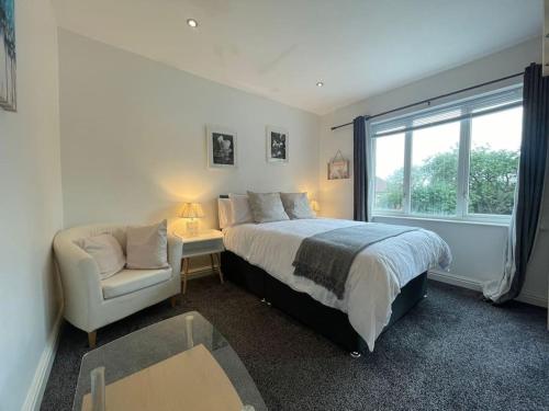 a bedroom with a bed and a chair and a window at Kingsbury Apt 2 in Birmingham