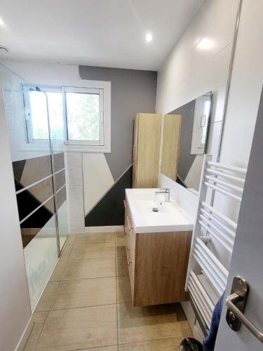 une salle de bain avec un lavabo et une douche dans l'établissement Villa design jacuzzi et clim, à Brens