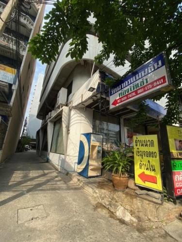 a building with signs on the side of it at รัตนากร แมนชั่น in Bang Su