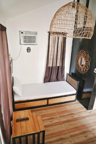 a small bed in a room with a table at SimoyNorte Private Resort Beneg, Botolan, Zambales, Philippines in Zambales