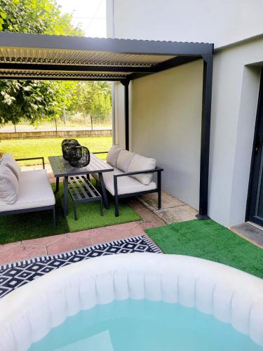 d'une terrasse avec une table, des chaises et une table de pique-nique. dans l'établissement Villa design jacuzzi et clim, à Brens