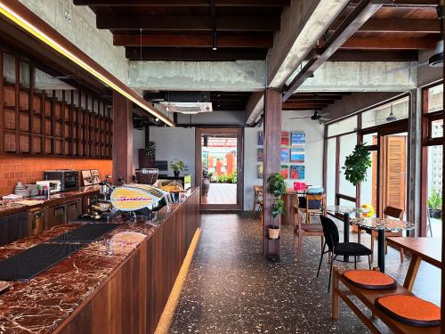a restaurant with a bar with tables and chairs at rongmai mahachai cafe and stay in Samut Sakhon