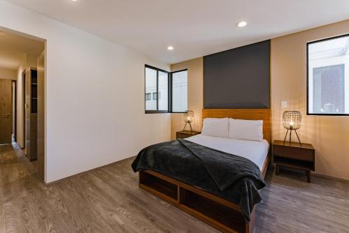 a bedroom with a large bed and two windows at Roma Sur Apartments by VH in Mexico City