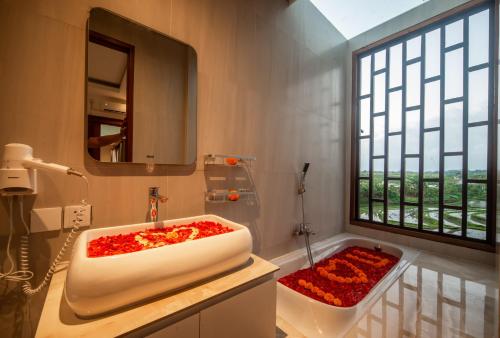 un bagno con un lavandino bianco e una finestra di Alvana Villa Canggu a Canggu