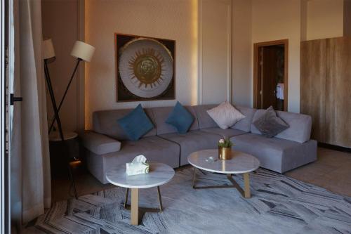 a living room with a couch and two tables at Gewan Palace New Alamein in El Alamein