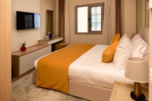 a hotel room with a bed and a television at Gewan Palace New Alamein in El Alamein