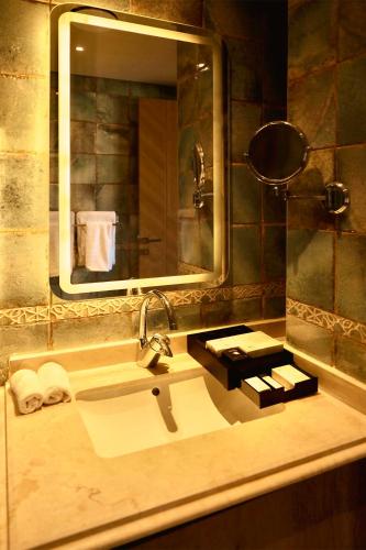 a bathroom with a sink and a large mirror at Gewan Palace New Alamein in El Alamein