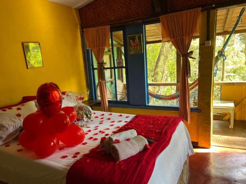 a bedroom with a bed with balloons on it at Pousada Lua Bonita in Nova Lima