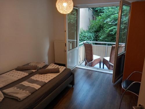 Un dormitorio con dos camas y un balcón. en Top Apartment 200 Meter zum Rheinauhafen, en Colonia