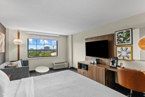 a hotel room with a bed and a flat screen tv at Holiday Inn Niagara Falls State Park Entry by IHG in Niagara Falls