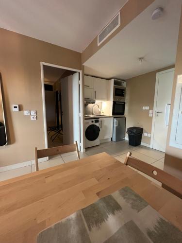 Il comprend un salon avec une table en bois et une cuisine. dans l'établissement T2 Marseille Plage, à Marseille