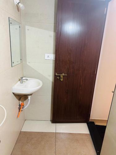a bathroom with a wooden door and a sink at Vallyath Ayurveda By BRDGE HOSPITALITY in Ernakulam