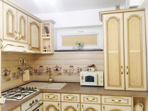 a kitchen with white cabinets and a white microwave at Apartament Modern in Craiova