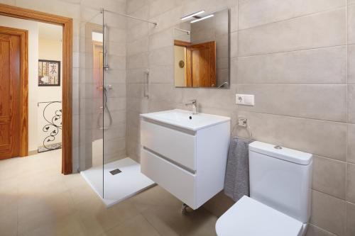 a bathroom with a toilet and a sink and a shower at Villa ju-mi in El Cerro