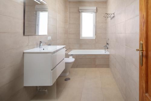a bathroom with a sink and a tub and a toilet at Villa ju-mi in El Cerro