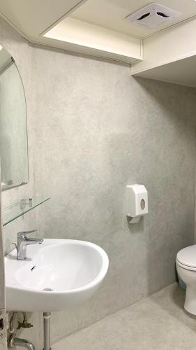 a bathroom with a sink and a toilet at 嵐茵鐵道旅館 in Tainan