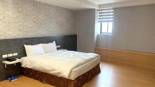 a bedroom with a bed and a brick wall at 嵐茵鐵道旅館 in Tainan