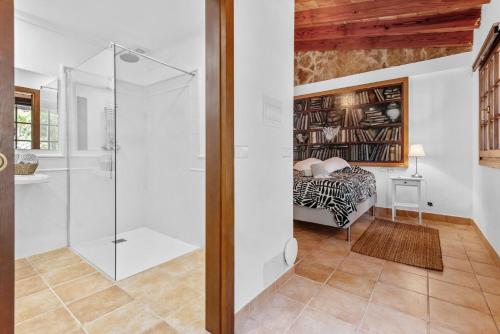 a bathroom with a glass shower and a bed at Finca Especial El Pino en Esporles in Esporles