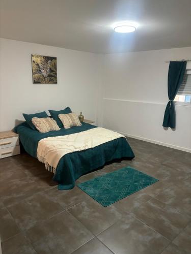 une chambre avec un lit dans une pièce blanche dans l'établissement Maison de ville, à Listrac-Médoc