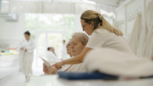 a woman is looking at a tablet next to a patient at Logis Thermal in Saubusse