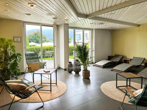a living room with chairs and tables and windows at Seehotel Kastanienbaum in Luzern