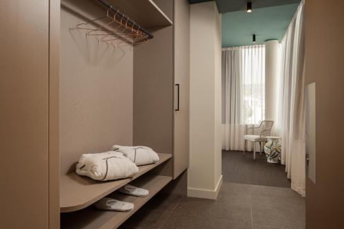 a room with a bed with towels on a shelf at WANDERLUST HOTEL - SUITE & SPA - APARTMENTS & VILLAS - Bardolino, Lago di Garda - Verona in Bardolino