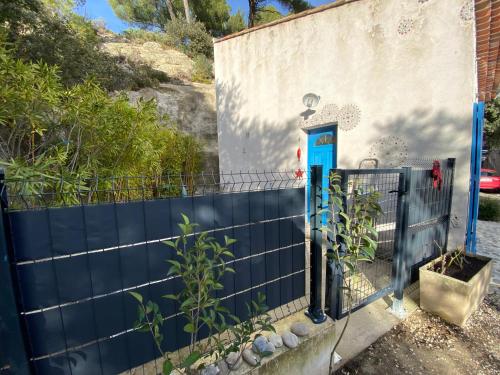 a blue fence in front of a house at Maisonnette entre Luberon et Sainte Victoire in La Bastidonne