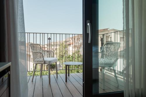 a balcony with two chairs and a table at WANDERLUST HOTEL - SUITE & SPA - APARTMENTS & VILLAS - Bardolino, Lago di Garda - Verona in Bardolino