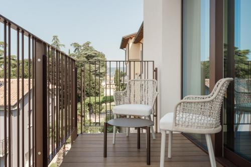 two chairs and a table on a balcony at WANDERLUST HOTEL - SUITE & SPA - APARTMENTS & VILLAS - Bardolino, Lago di Garda - Verona in Bardolino