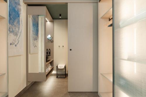 a hallway with white walls and a glass door at WANDERLUST HOTEL - SUITE & SPA - APARTMENTS & VILLAS - Bardolino, Lago di Garda - Verona in Bardolino