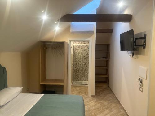ein Schlafzimmer mit einem Bett und einem Fernseher in einem Zimmer in der Unterkunft Attic room in Neapel