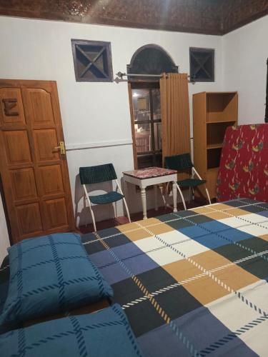 a bedroom with a bed and a table and chairs at Mini Tiga Homestay in Pangandaran