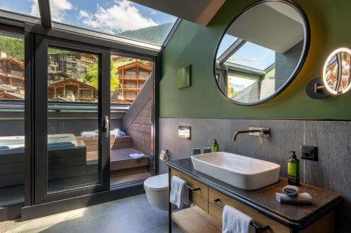 a bathroom with a sink and a mirror at Hotel ZERMAMA Zermatt in Zermatt