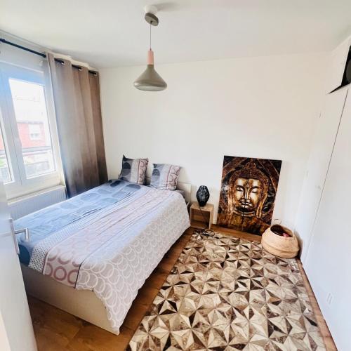 a bedroom with a bed and a painting on the wall at zenitude in Marquette-lès-Lille