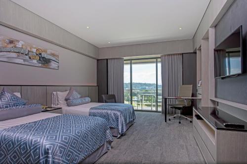 a hotel room with two beds and a flat screen tv at The Pacific Sutera Hotel in Kota Kinabalu
