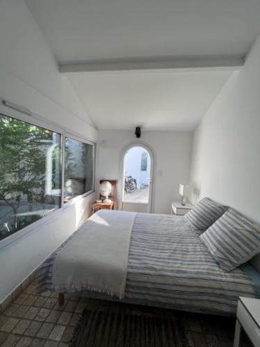 une chambre avec un grand lit et une grande fenêtre dans l'établissement Villa pieds dans la mer de la Cote bleue, à Martigues