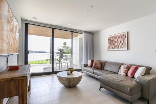 a living room with a couch and a table at Bayfront Holiday Retreat with Parking in Batemans Bay