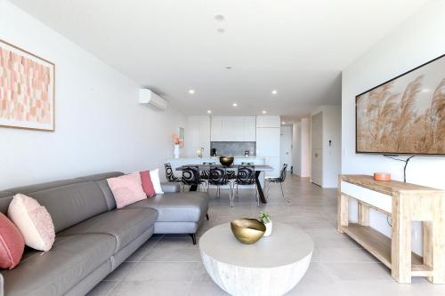 a living room with a couch and a table at Bayfront Holiday Retreat with Parking in Batemans Bay