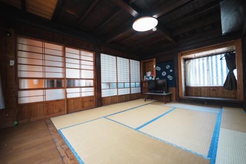 a room with a large rug in a room with windows at ペンションとみや 1組限定 in Oshima