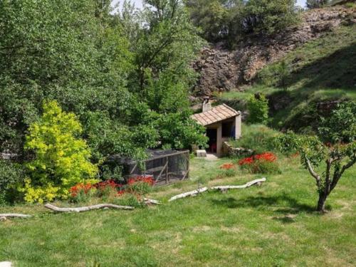 a house in a field with flowers and trees at El Molí Nou - Rural flats in Peñarroya de Tastavins