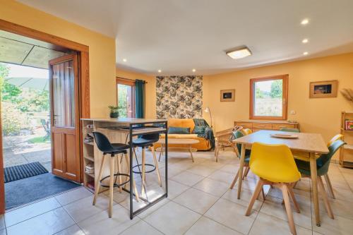 a kitchen and living room with a table and chairs at Gîte Les Bambous in Saint-Antoine