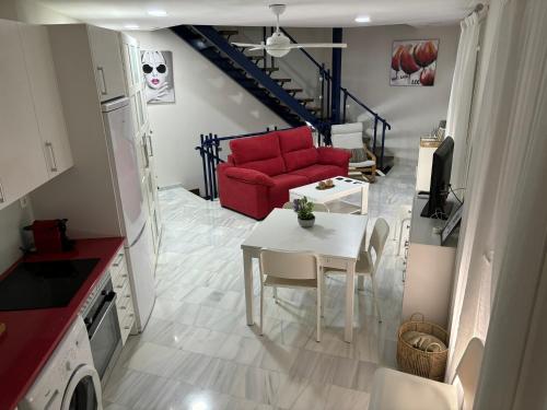 a living room with a red couch and a table at Casa Yaye Centro Écija in Écija