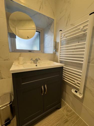 un bagno con lavandino e specchio di Krugers Guest House a Dunquin