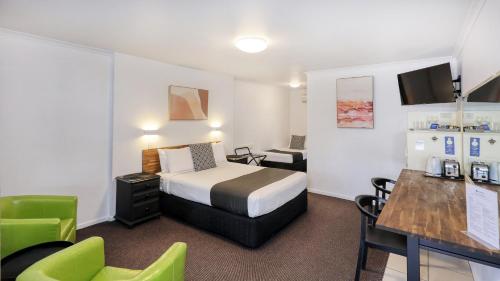 a hotel room with a bed and a table and chairs at Best Western Caboolture Gateway Motel in Caboolture
